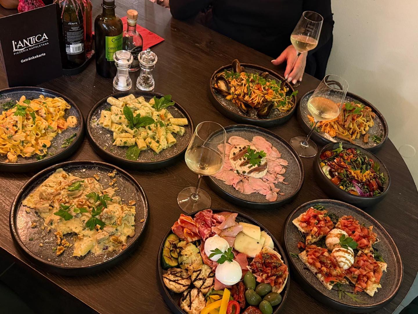 Gedeckter Tisch mit Pasta, Salat und Antipasti bei L'Antica Pizzeria Stuttgart