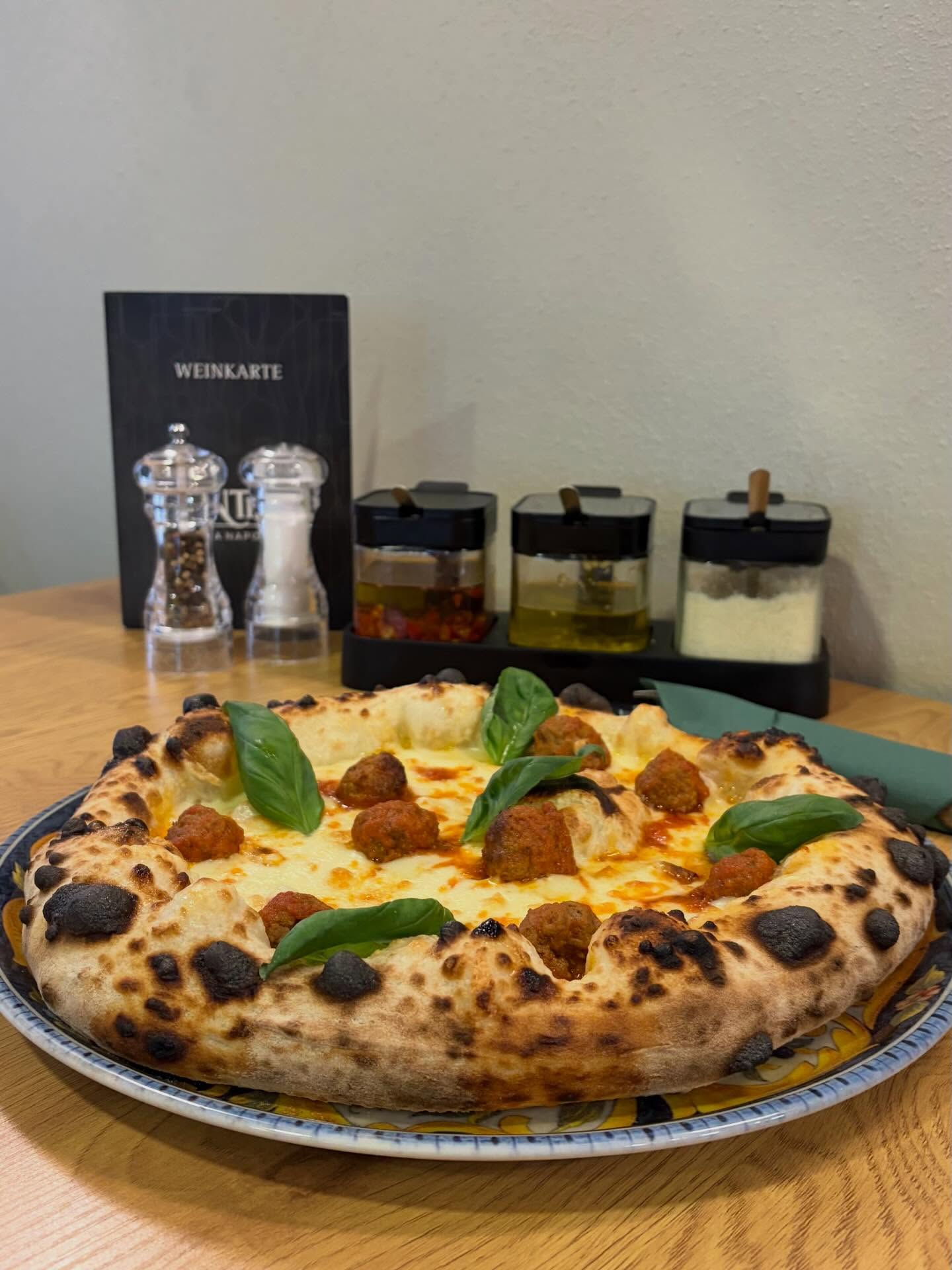 Pizza mit hausgemachten Polpette-Fleischbällchen und Basilikum